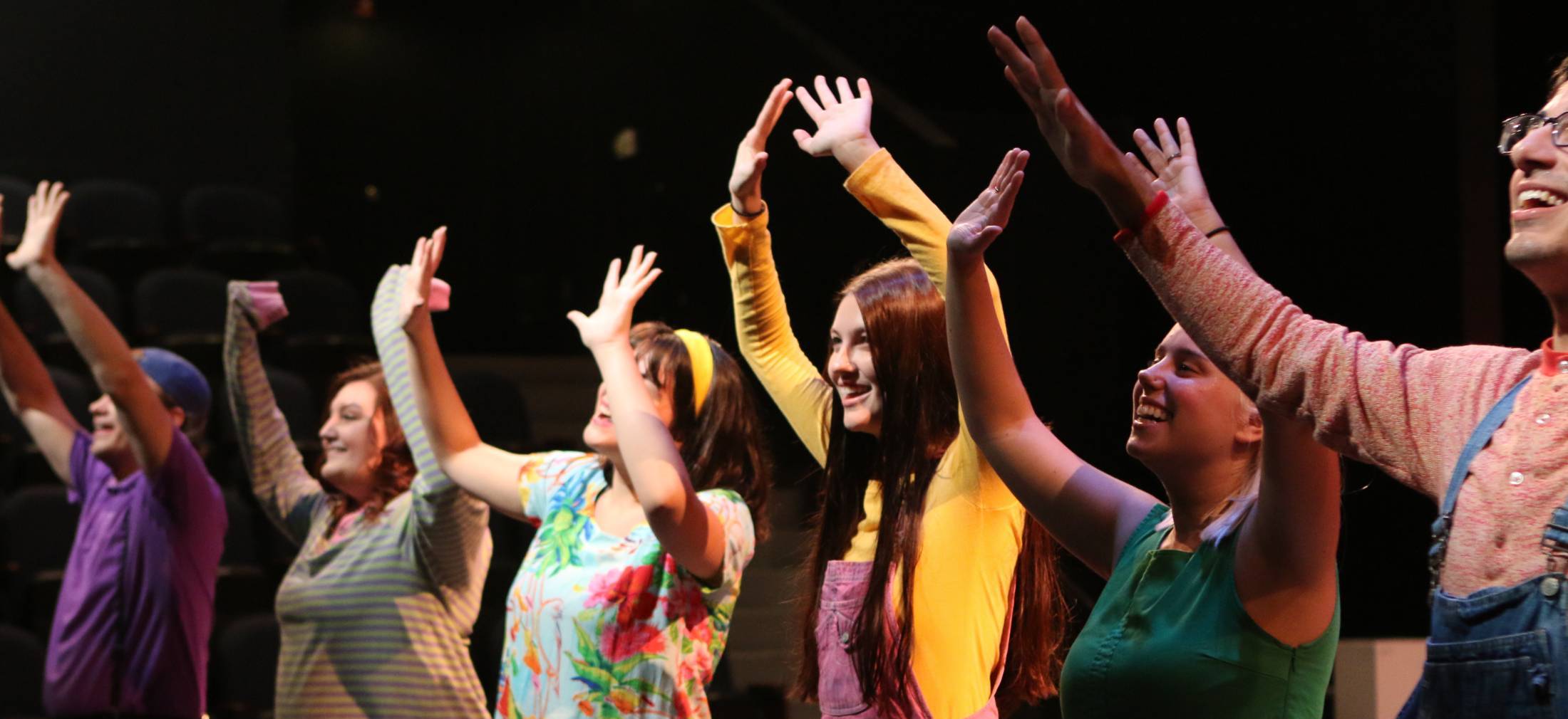 actors on stage sitting a tables with bowls performing Sister Act