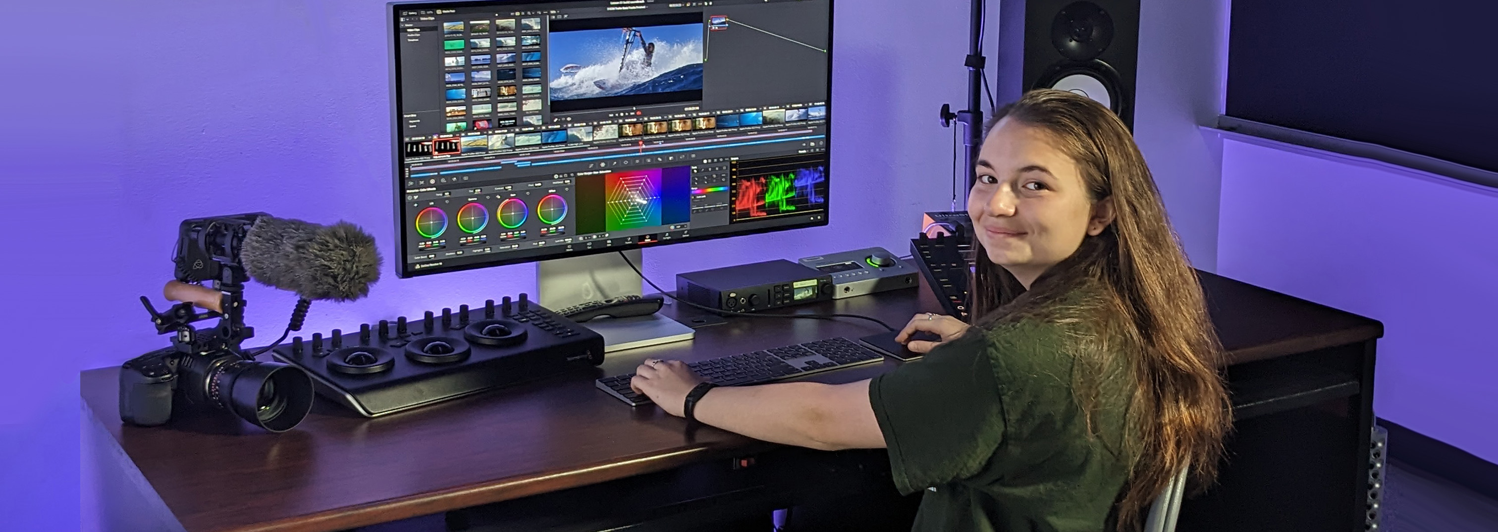 student around a work table with computer and media equipment