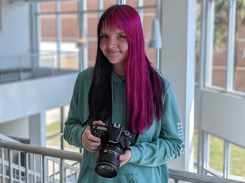 student with camera in photo building
