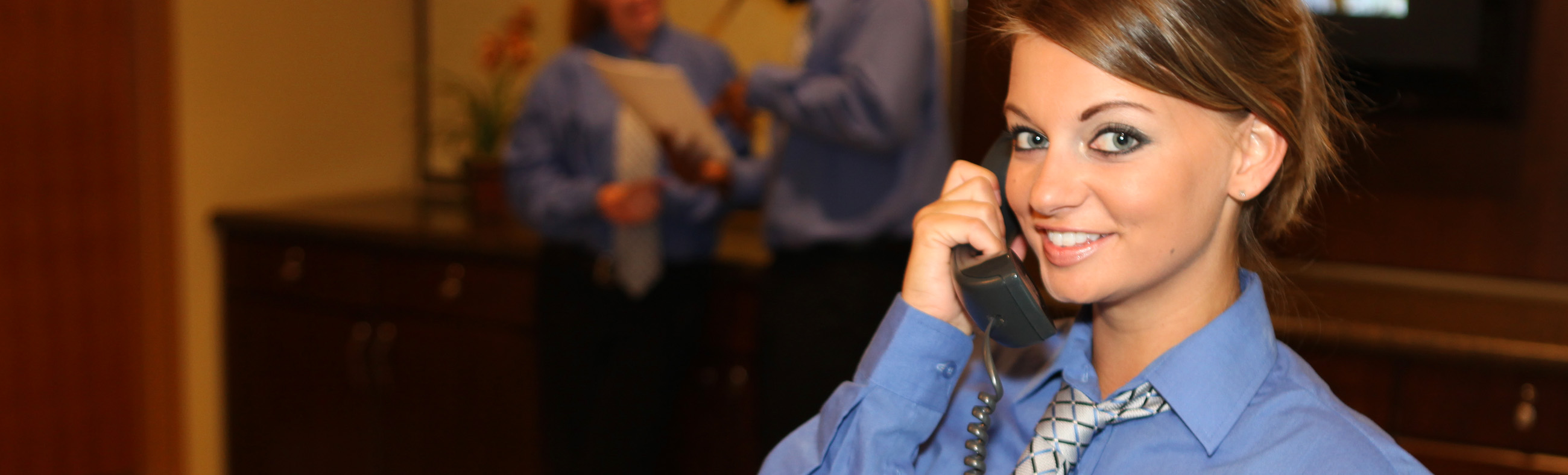 Female Hospitality Management worker answering the phone. 