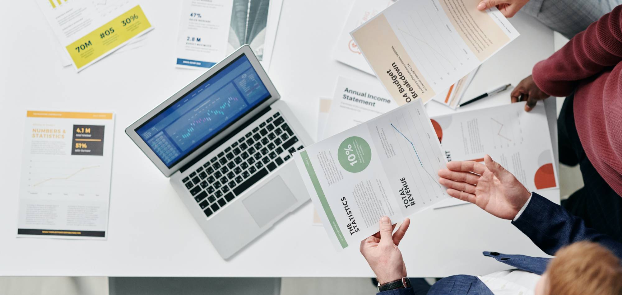 People reviewing accounting documents on a desk.