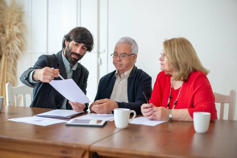 insurance agent with clients reviewing documents