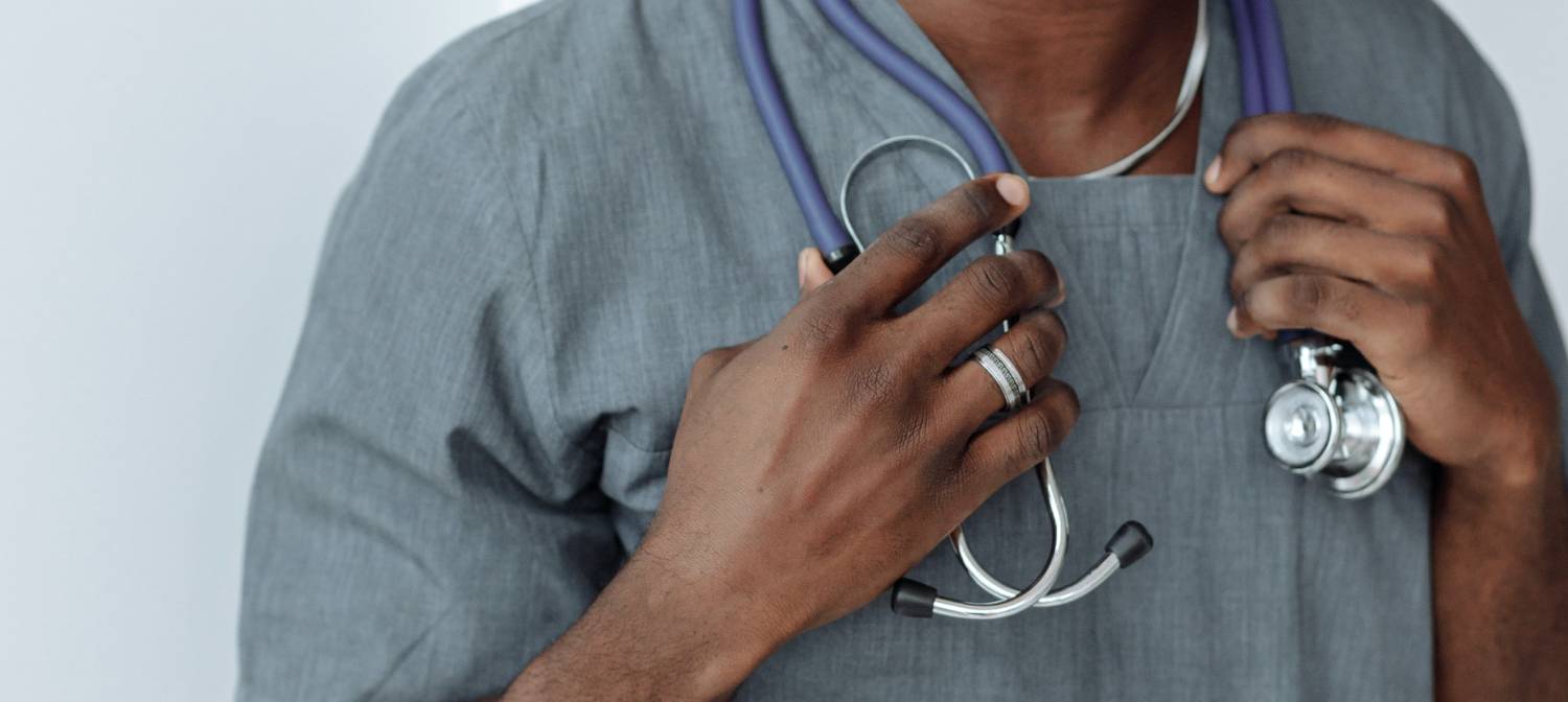 nurse in grey scrubs with stethoscope around neck