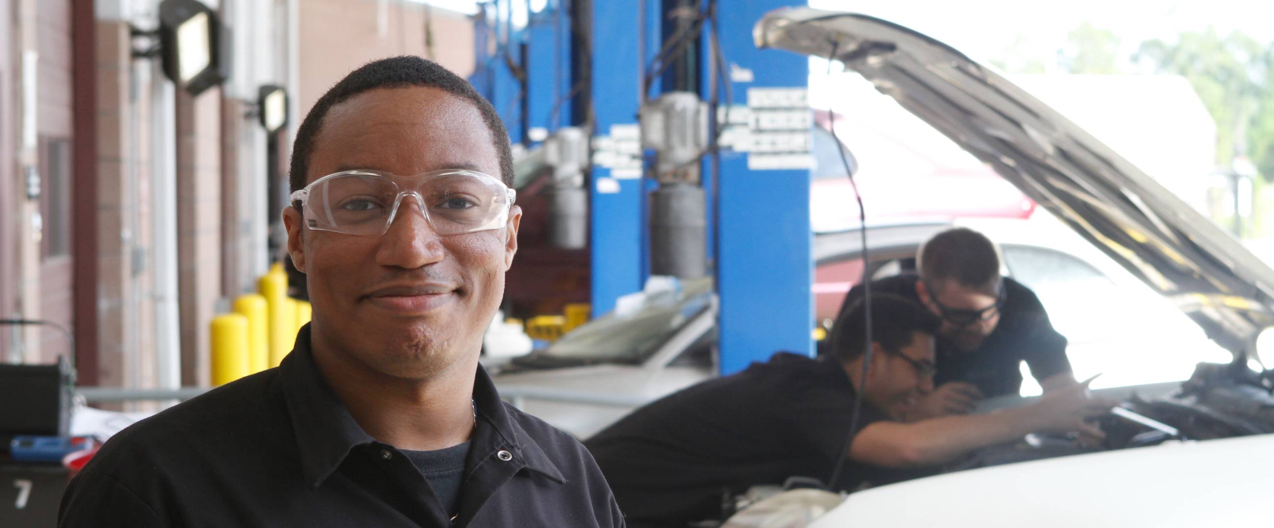 student with safety glasses in automotive bay