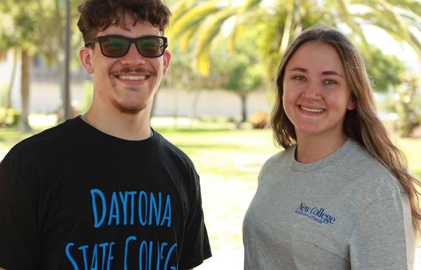 student in black Daytona State College tshirt and another student in grey New College tshirt