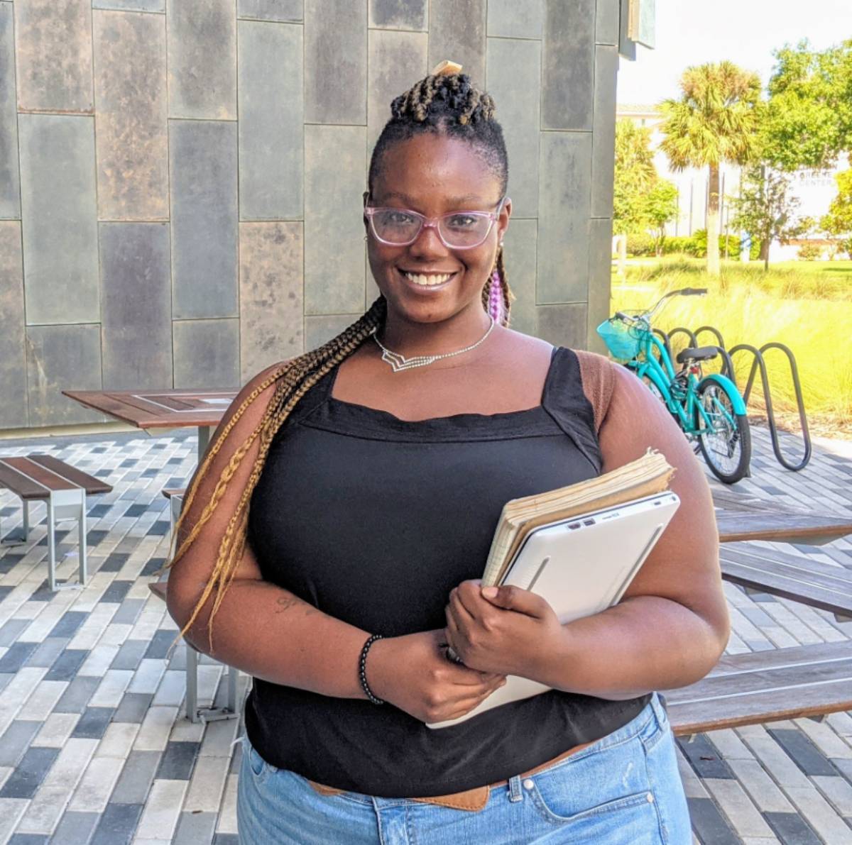 student outside Student Center carrying books