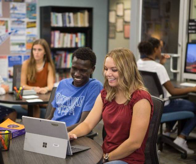 two students working together on a laptop