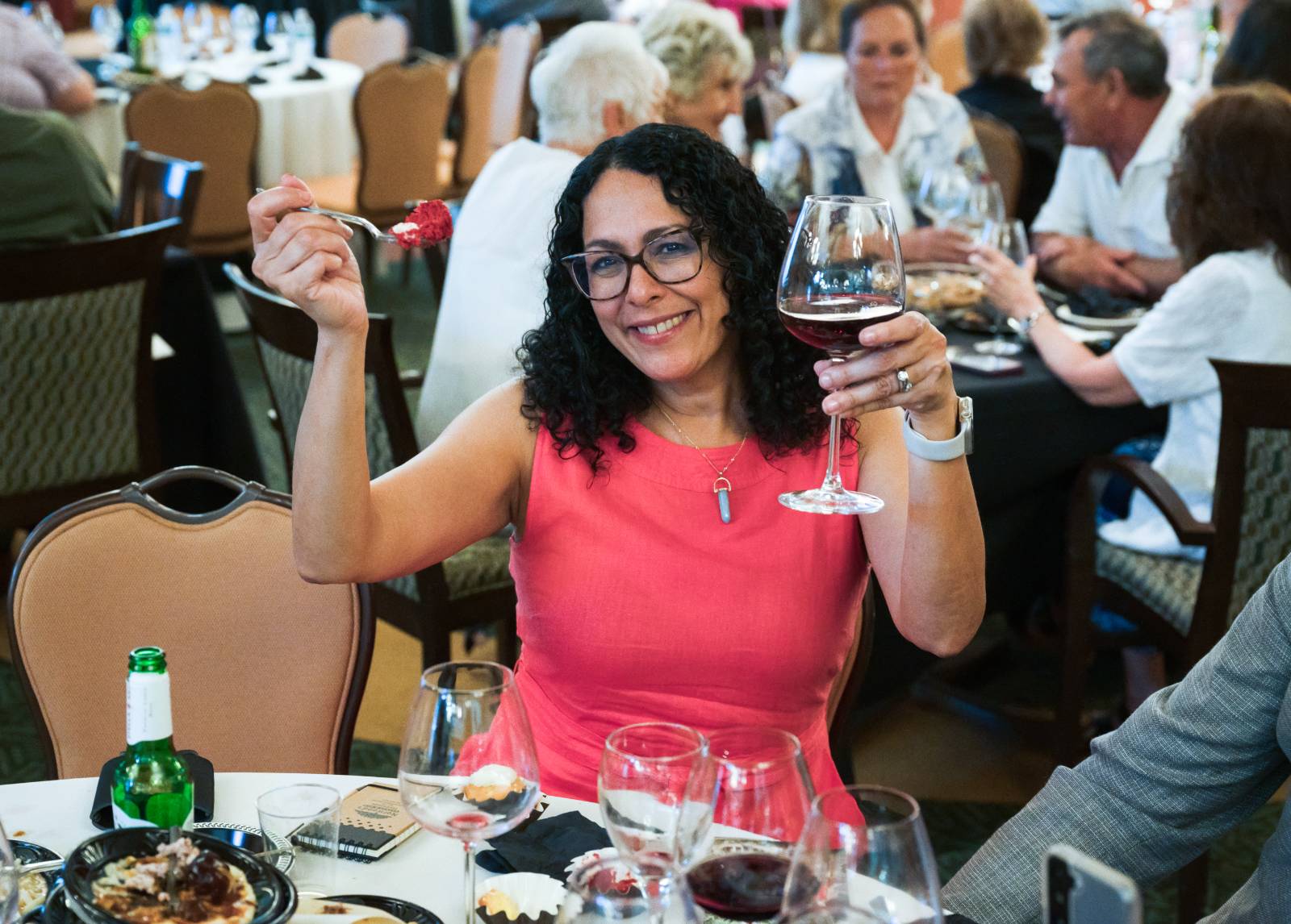 A woman enjoying some wine and food and an event.