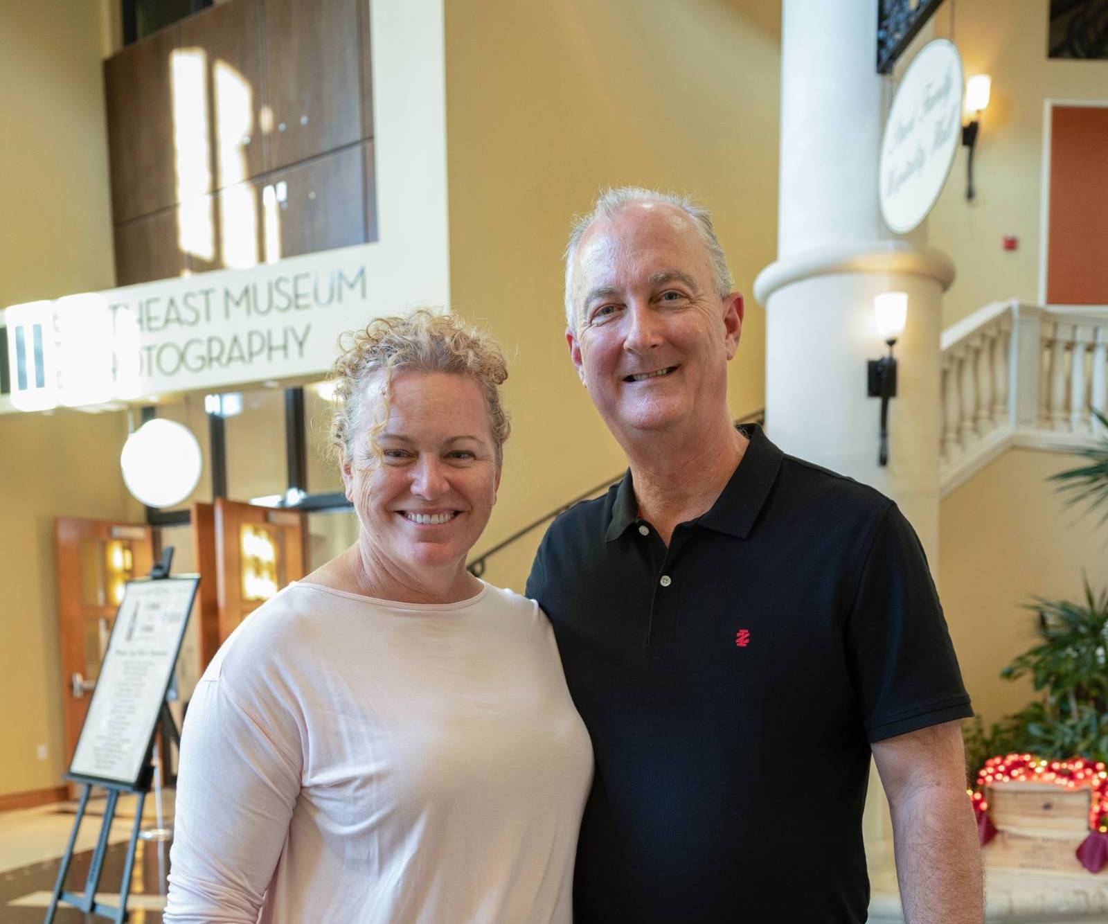 Two attendees smiling in the hall.