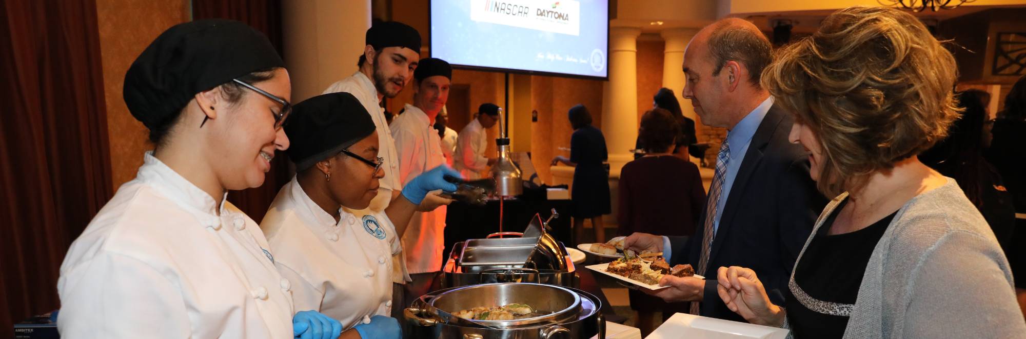 culinary students serving guests at the annual gala