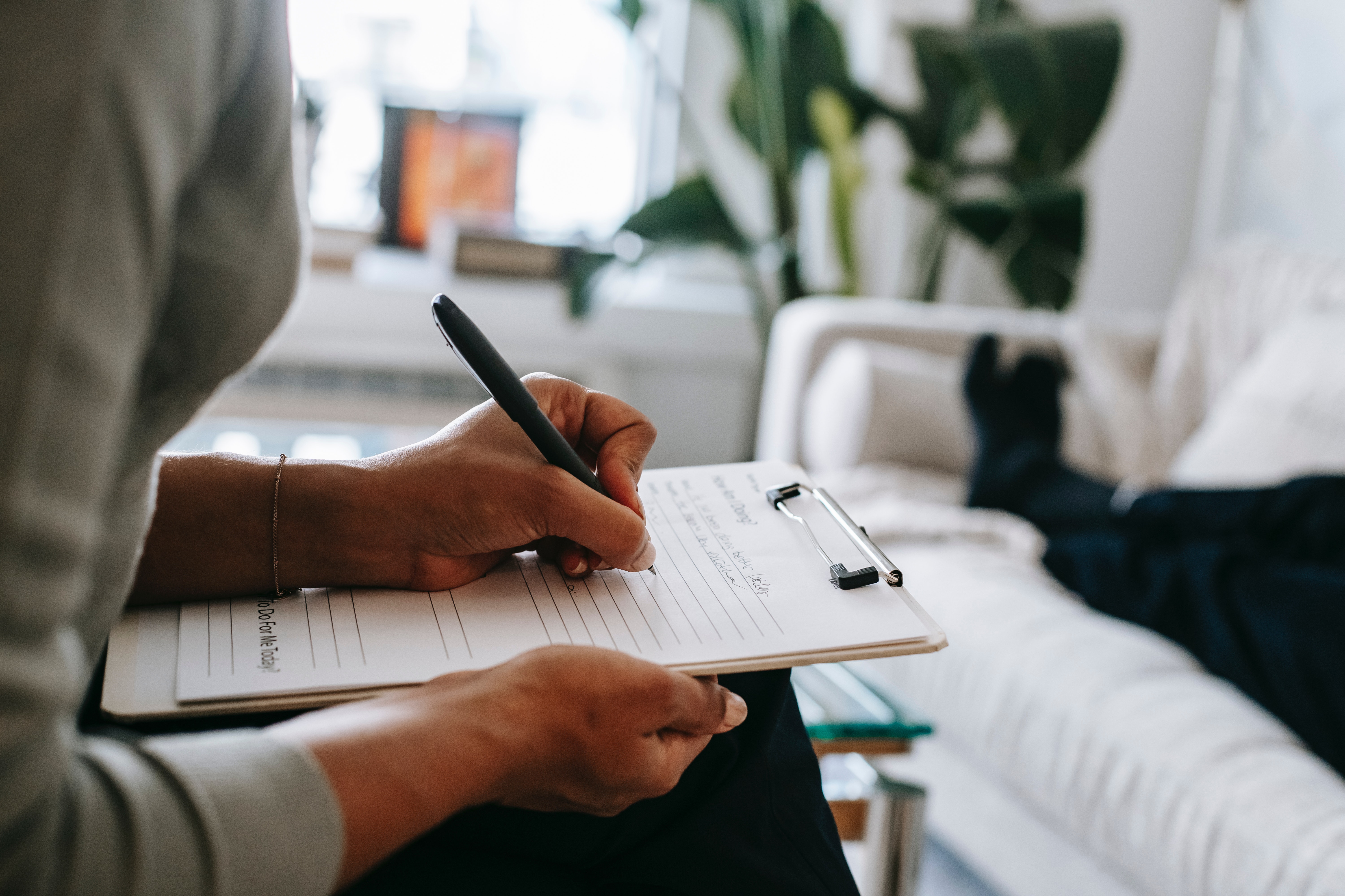 close up of person writing on a clipboard