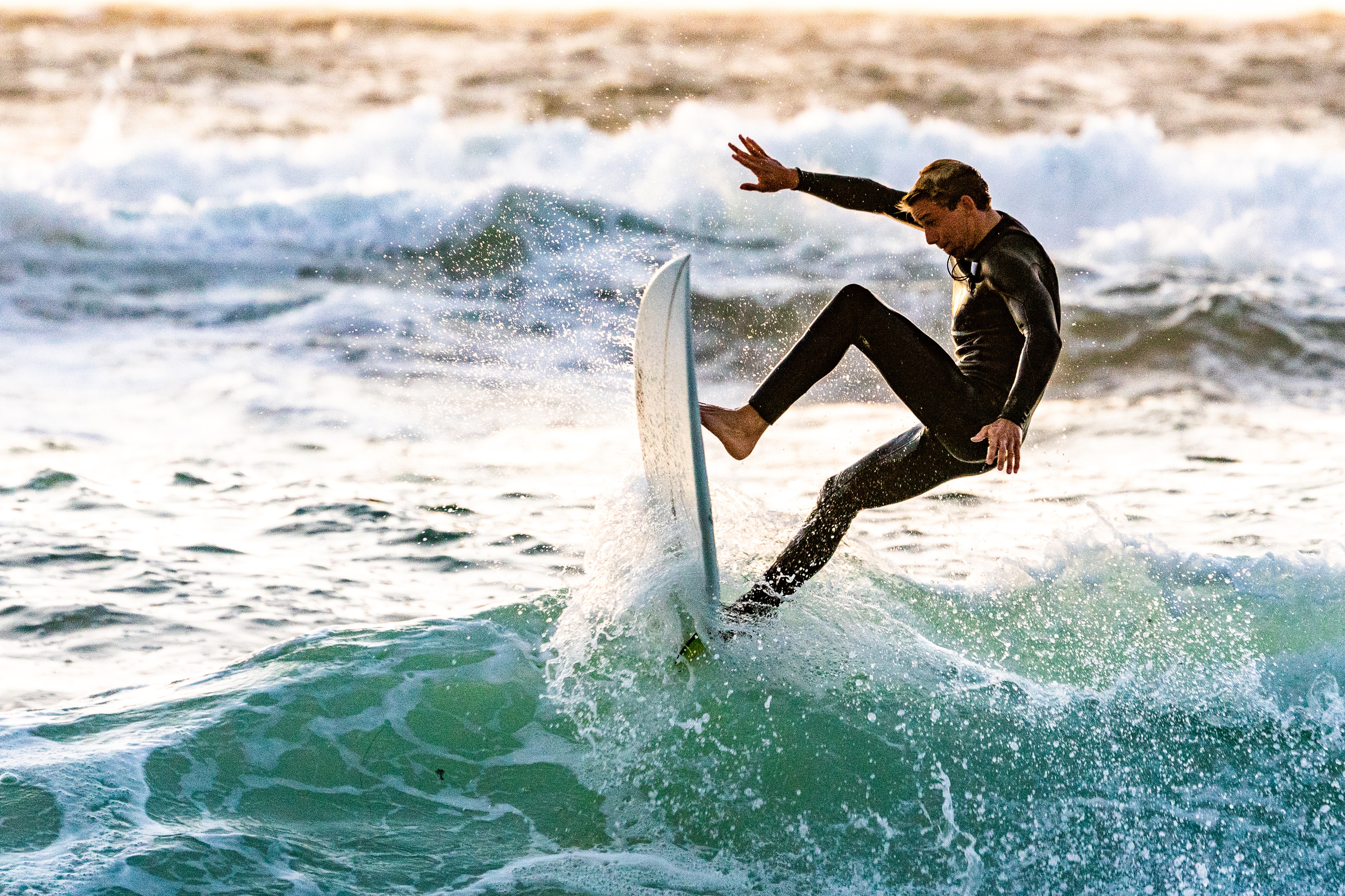 person in wetsuit surfing
