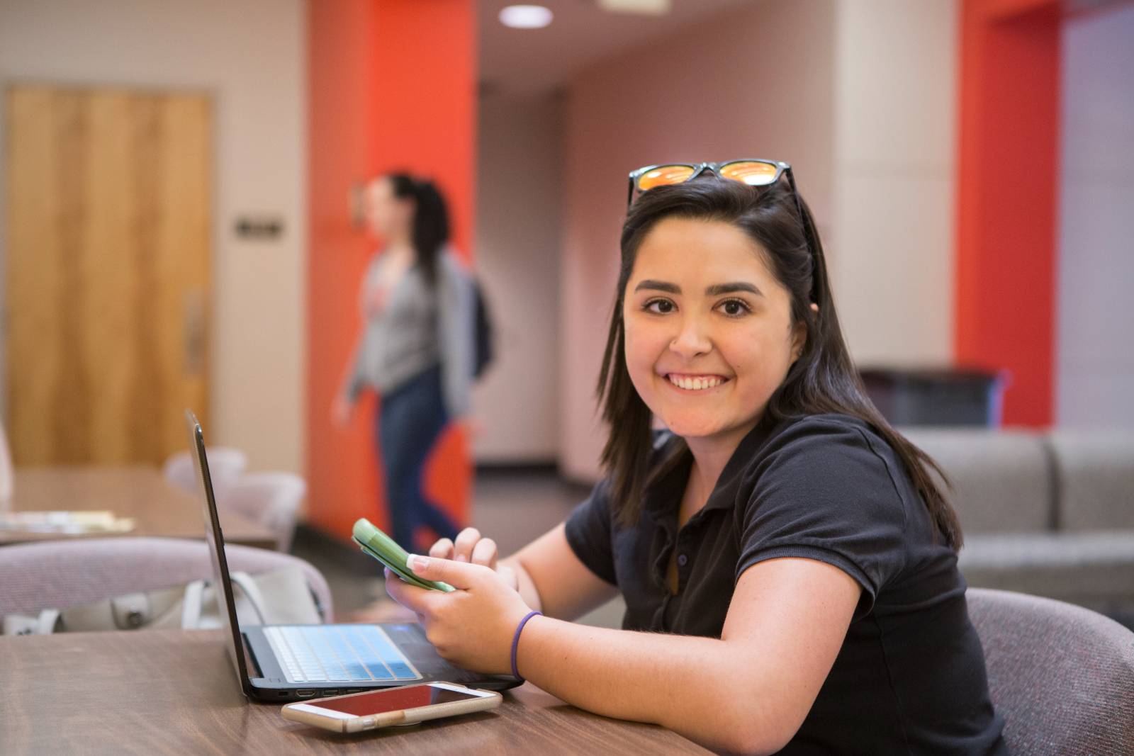 student at table with sunglasses on their head