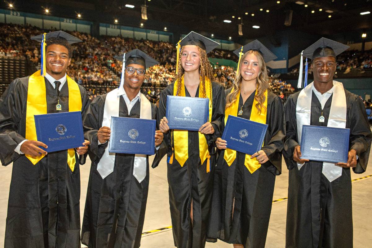 Two students decorate their caps for graduation. 