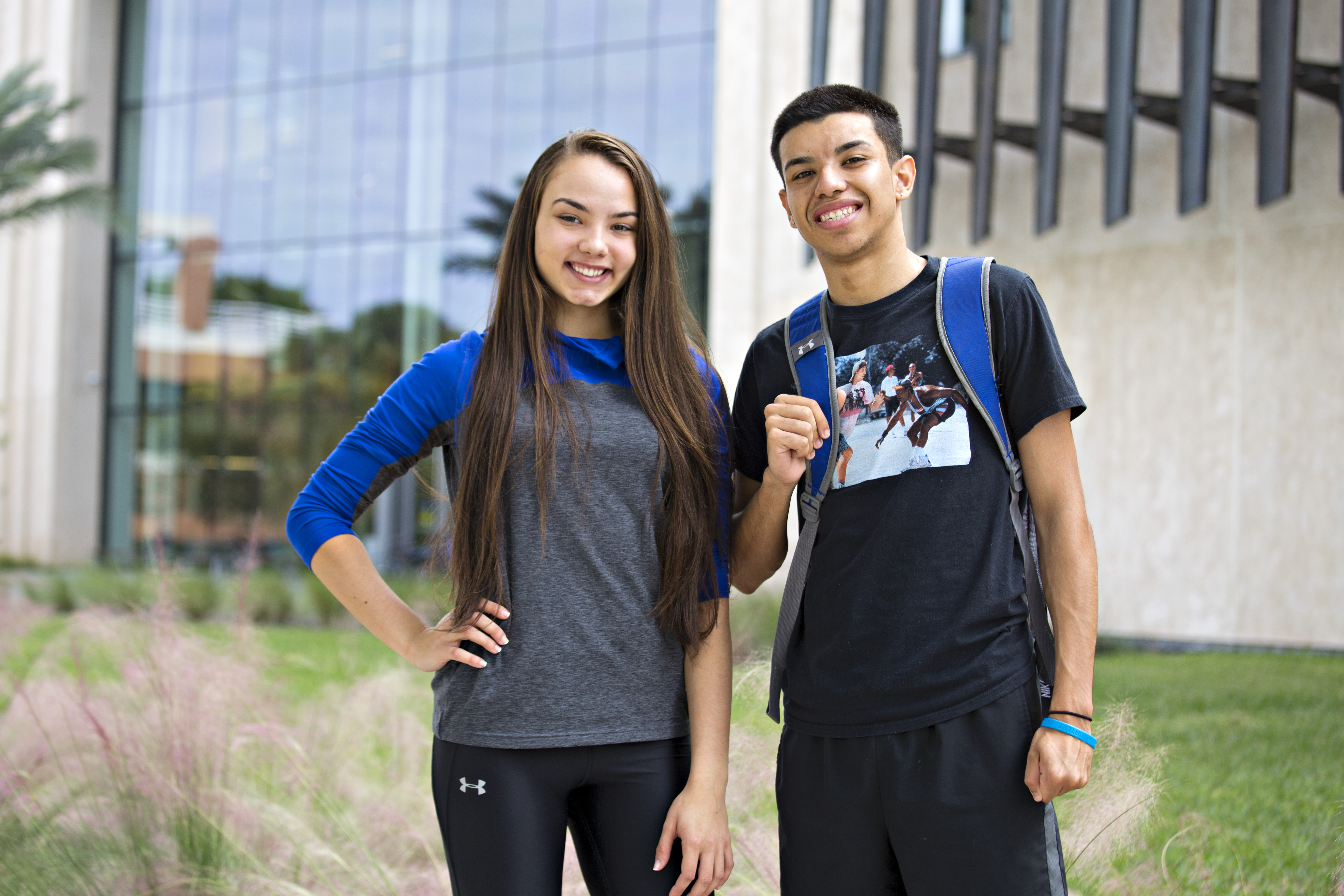 Two students smiling outside.