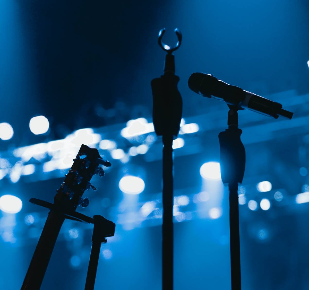 guitar and microphone on stage in blue lighting