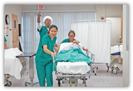 image of Daytona State College nursing students in lab with patient on gurney