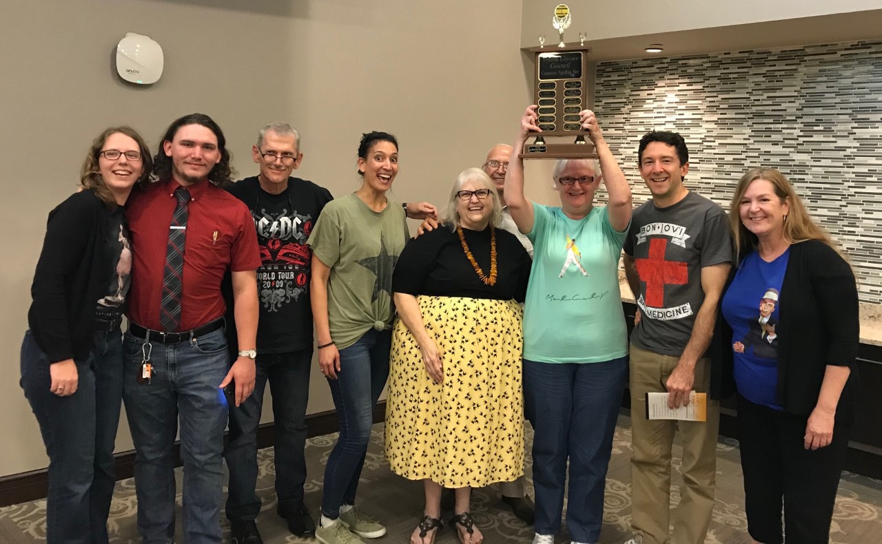 image of winning spelling bee team members: Jeff Ferguson, Ben Graydon, Frank Gunshanan (team member and captain), Maggie Karda, Sally MacGee, Susan Ortiz, Rachel Owens, and Augusta Thomas.