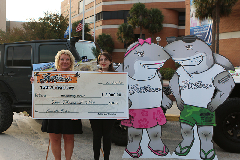 Charlene Greer, Jeep Beach executive board member, left, presents a check to Samantha Bodnar for her winning Jeep Beach mascots, Ruby and Willy, right.