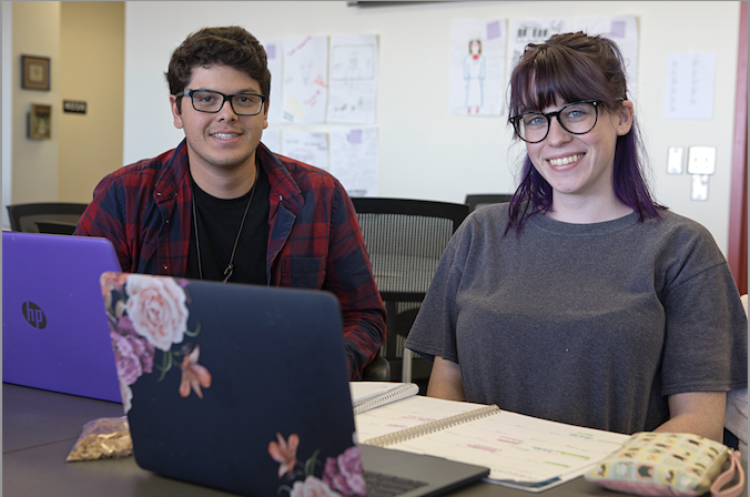 two student with laptops working together