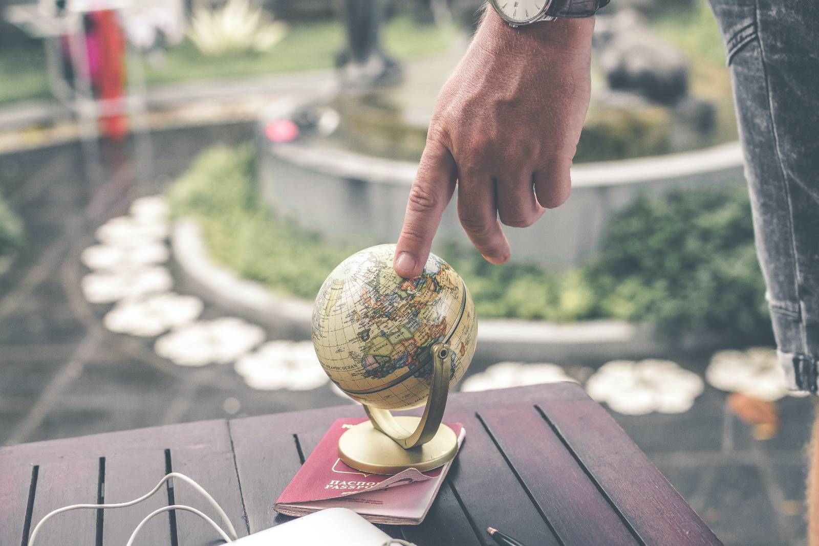 finger pointing on a small globe