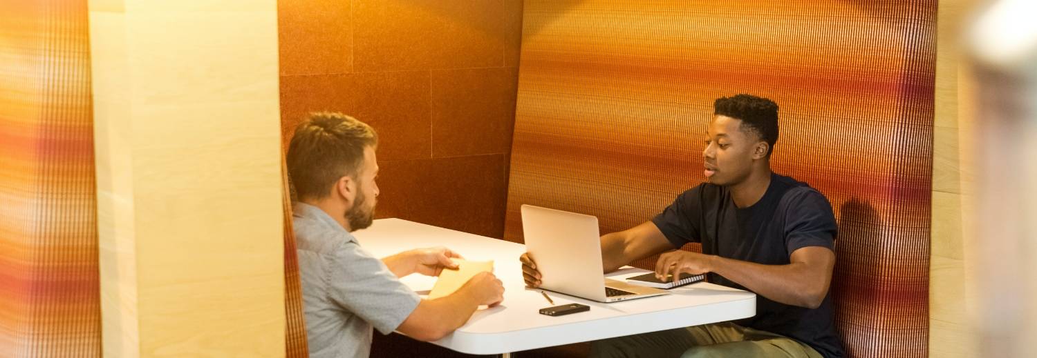 two people collaborating in a booth