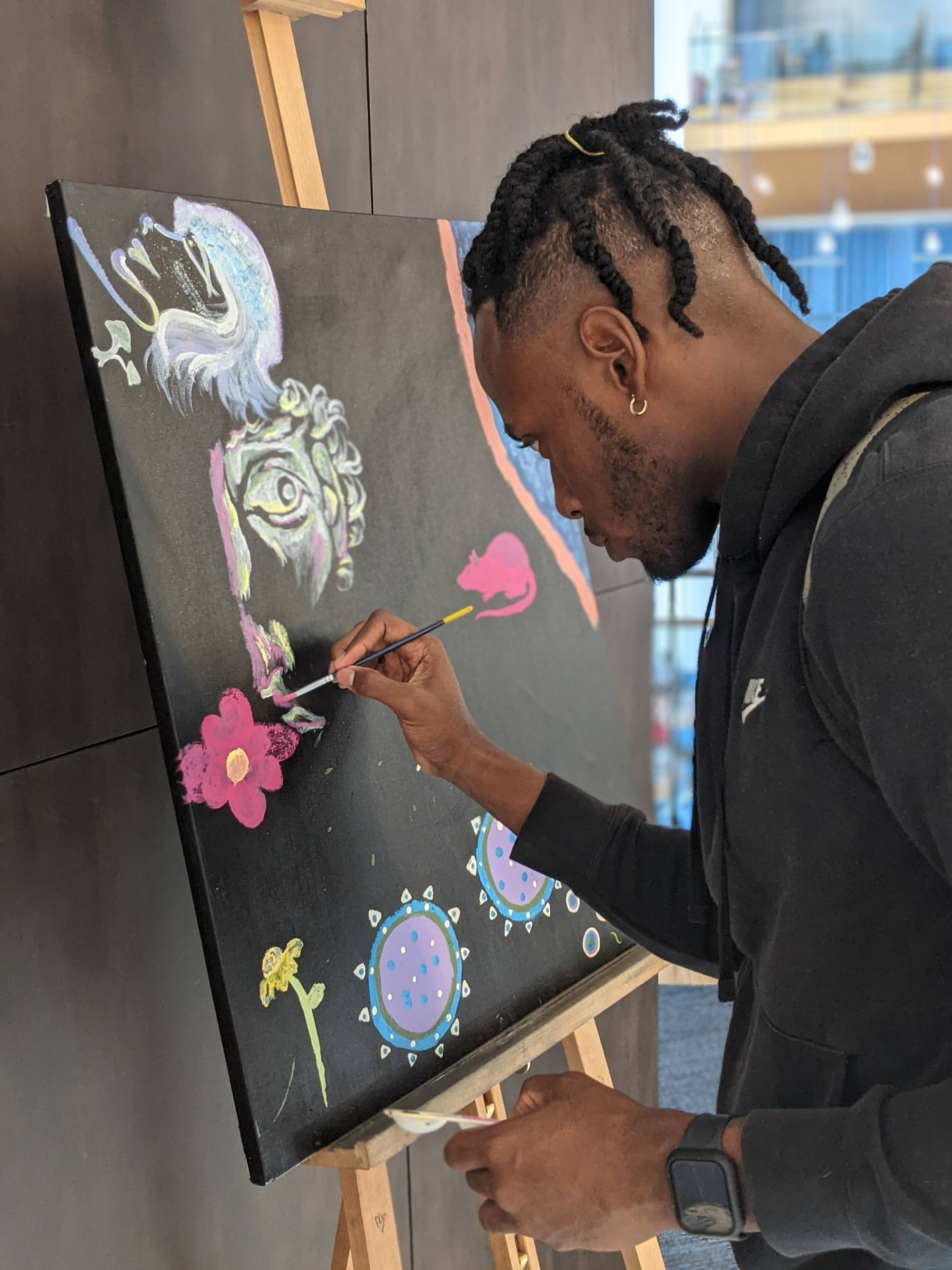 A student painting at a campus event. 